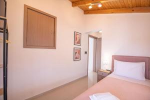 a bedroom with a bed and a cabinet on the wall at The Archanes Sapphire in Archanes