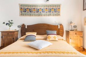 1 dormitorio con cama de madera y almohadas en B&B Su Biancu - Sardinian Experience, en Urzulei