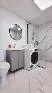 een badkamer met een douche en een wasmachine bij Võru Kodu 2 in Võru