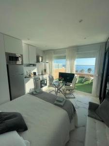a bedroom with a bed and a kitchen with a view of the ocean at Coqueto estudio-ático EN PRIMERA LÍNEA DE PLAYA CON PRECIOSAS VISTAS AL MAR in Almería