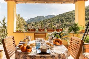 una mesa en un balcón con vistas a las montañas en B&B Su Biancu - Sardinian Experience en Urzulei