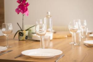 a table with wine glasses and a plate on it at Nouveau - Le Luminosa - Centre ville in Haguenau