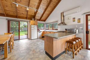 a kitchen with wooden ceilings and a wooden counter top at Beilby Beach Cottage in Inverloch