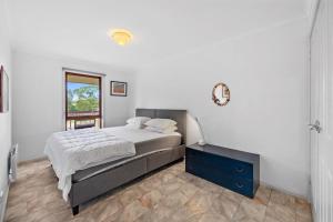 una camera da letto con un letto con un comò blu e una finestra di Beilby Beach Cottage a Inverloch