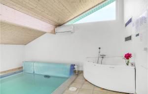 łazienka z wanną i basenem w obiekcie Nice Home In Væggerløse With Sauna w mieście Bøtø By