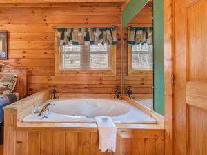 baño con bañera en una cabaña de madera en Dew South, 2 Bedrooms, Sleeps 8, Views, Arcade, Hot Tub, Pet Friendly, en Gatlinburg