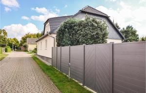a fence in front of a house at Awesome Apartment In Wusterhusen in Wusterhusen