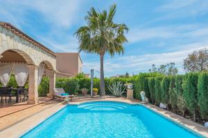 a swimming pool in a yard with a palm tree at Casa Mayor Strand Es Trenc 5 min in Sa Ràpita