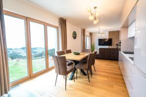 a kitchen and dining room with a table and chairs at Family apartment Kubínska Hoľa in Dolný Kubín +2 photos