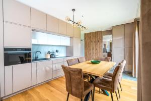 cocina y comedor con mesa de madera y sillas en Family apartment Kubínska Hoľa, en Dolný Kubín