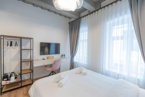 una camera con letto, scrivania e TV di Richter Residence a Braşov