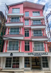 大吉嶺的住宿－Hotel Sonar Bangla Darjeeling，粉红色的建筑,前面有标志