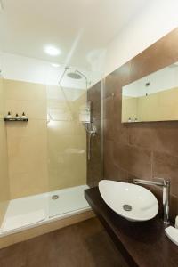 uma casa de banho com um lavatório e um chuveiro em SuitInn19 em Roma