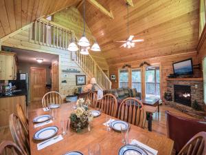 a dining room and living room with a table in a cabin at Bear’s Corner, 3 Bedrooms, WiFi, Pool Table, Hot Tub, WiFi, Sleeps 10 in Gatlinburg