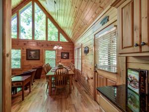 a dining room in a log cabin with a table and chairs at Bear’s Corner, 3 Bedrooms, WiFi, Pool Table, Hot Tub, WiFi, Sleeps 10 in Gatlinburg