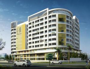 un grande edificio con macchine parcheggiate di fronte di Hotel Heraa International a Mangalore