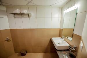 a bathroom with a sink and a mirror at Hotel Heraa International in Mangalore