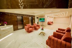 a lobby with chairs and a table and a screen at Hotel Heraa International in Mangalore