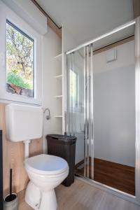 La salle de bains est pourvue de toilettes et d'une douche en verre. dans l'établissement Luxury Mobile home Zuzu Klenovica, à Klenovica