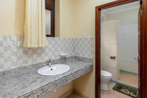 a bathroom with a sink and a toilet at Victoria Breeze Suites, Entebbe in Entebbe