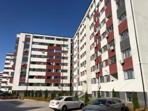 two cars parked in front of a large building at Relax Apartment Militari Residence Sector 6 in Roşu