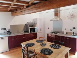 cocina con mesa de madera en una habitación en Gîte du Fassac en Saint-Julien-du-Puy