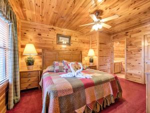 1 dormitorio con 1 cama y ventilador de techo en Apple Bear Lodge, 4 Bedrooms, Sleeps 18, Jacuzzis, Pool Table, Hot Tub en Gatlinburg