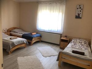 カポシュヴァールにあるTüskevár Vendégházのベッド2台と窓が備わる客室です。