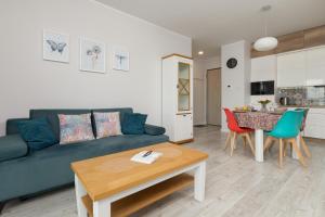 a living room with a blue couch and a table at Deluxe Apartments Sucha Gdańsk by Renters in Gdańsk