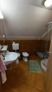 a bathroom with two toilets and a sink and a tub at Vascsacsi Nyaraló in Orosháza