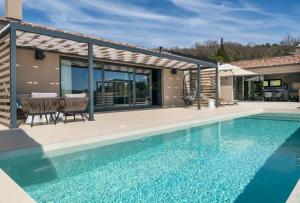 a swimming pool in front of a house at Villa Noeli in Hum