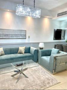 a living room with two blue couches and a table at Lux Burj views -Boulevard -Prime Location Downtown DUBAI in Dubai