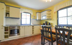 eine Küche mit gelben Wänden sowie einem Tisch und Stühlen in der Unterkunft Ferienhaus Wendisch-Rietz Seeadler, Luisenaue in Wendisch Rietz
