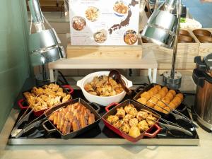 a group of trays of food on a counter at Vessel Inn Takadanobaba Ekimae in Tokyo