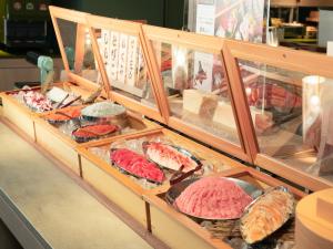 a display case filled with lots of different types of meat at Vessel Inn Takadanobaba Ekimae in Tokyo