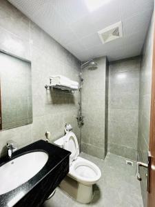 a bathroom with a sink and a toilet and a tub at Orion Hotel Halong in Ha Long
