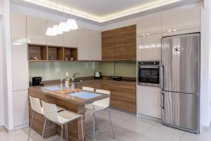 a kitchen with wooden cabinets and a stainless steel refrigerator at The Archanes Sapphire in Archanes