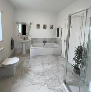 baño blanco con bañera y aseo en Ashlee Lodge P25 K6R6, en Shanagarry