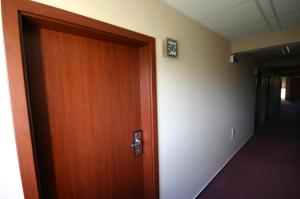 drewniane drzwi prowadzące do korytarza z korytarzem w obiekcie Hotel Ludmila w Mielniku