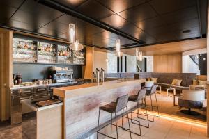 Eine Bar in einem Restaurant mit Theke und Stühlen in der Unterkunft Boutique Hotel Eschenlohe Adults only in Schenna