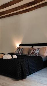 ein schwarzes Bett mit Kissen darauf in einem Zimmer in der Unterkunft Cesare Home in Palermo