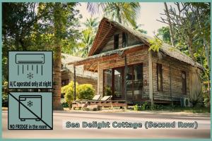a house with a sign that reads sea delphi cottage second row at Coco Cottage - SHA Plus in Ko Ngai