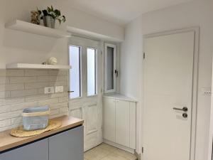 una cucina con pareti bianche e una porta bianca di Studio Mila a Piran