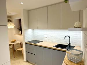 una cucina con mobili bianchi e un lavandino di Studio Mila a Piran