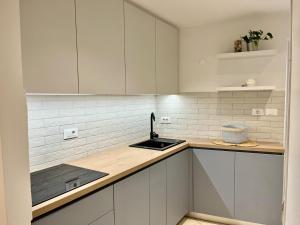 una cucina con mobili bianchi e un lavandino di Studio Mila a Piran Altre 10 foto