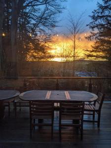 een tafel en stoelen met een zonsondergang op de achtergrond bij Cosy chalet in nature in Bastenaken