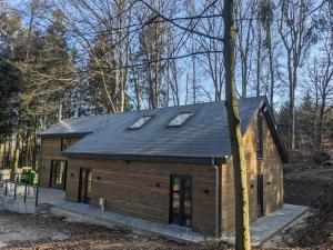 a small house with a roof on top of it at Cosy chalet in nature in Bastogne