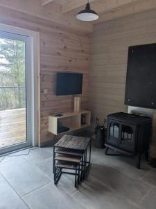 a living room with a fireplace and a flat screen tv at Cosy chalet in nature in Bastogne