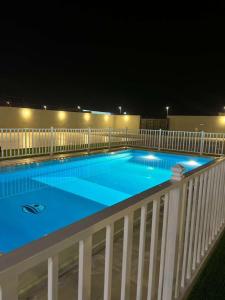 una piscina su un balcone di notte di شاليه ريفان a Umm Lajj