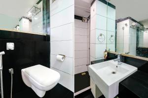 a bathroom with a white toilet and a sink at FabExpress We Stay in Mumbai